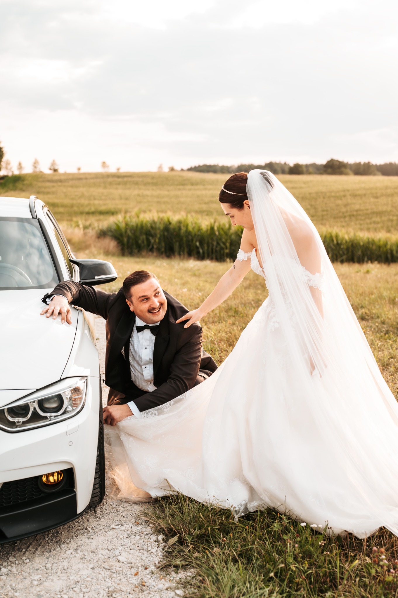 The two of us in wedding attire beside our white Touring.